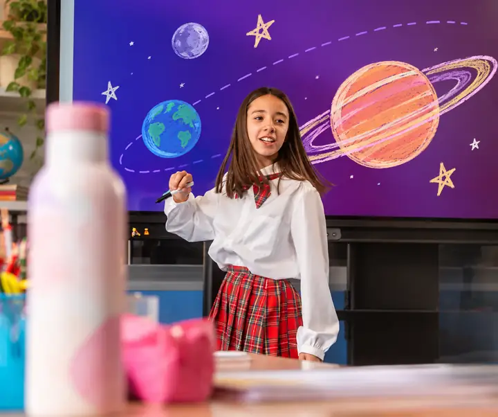 Student standing in front of a purple classroom screen after distracting marks are cleared